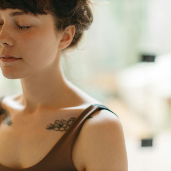 Person meditating peacefully in a calm, minimalist environment.